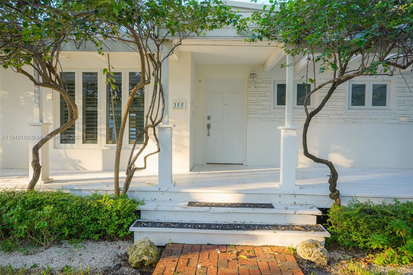 355 Redwood Lane Key Biscayne, FL 33149 - Photo 9 of 34 a front view of a house with a yard