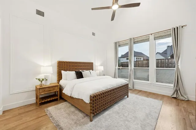 a bedroom with a bed lamp and a large window