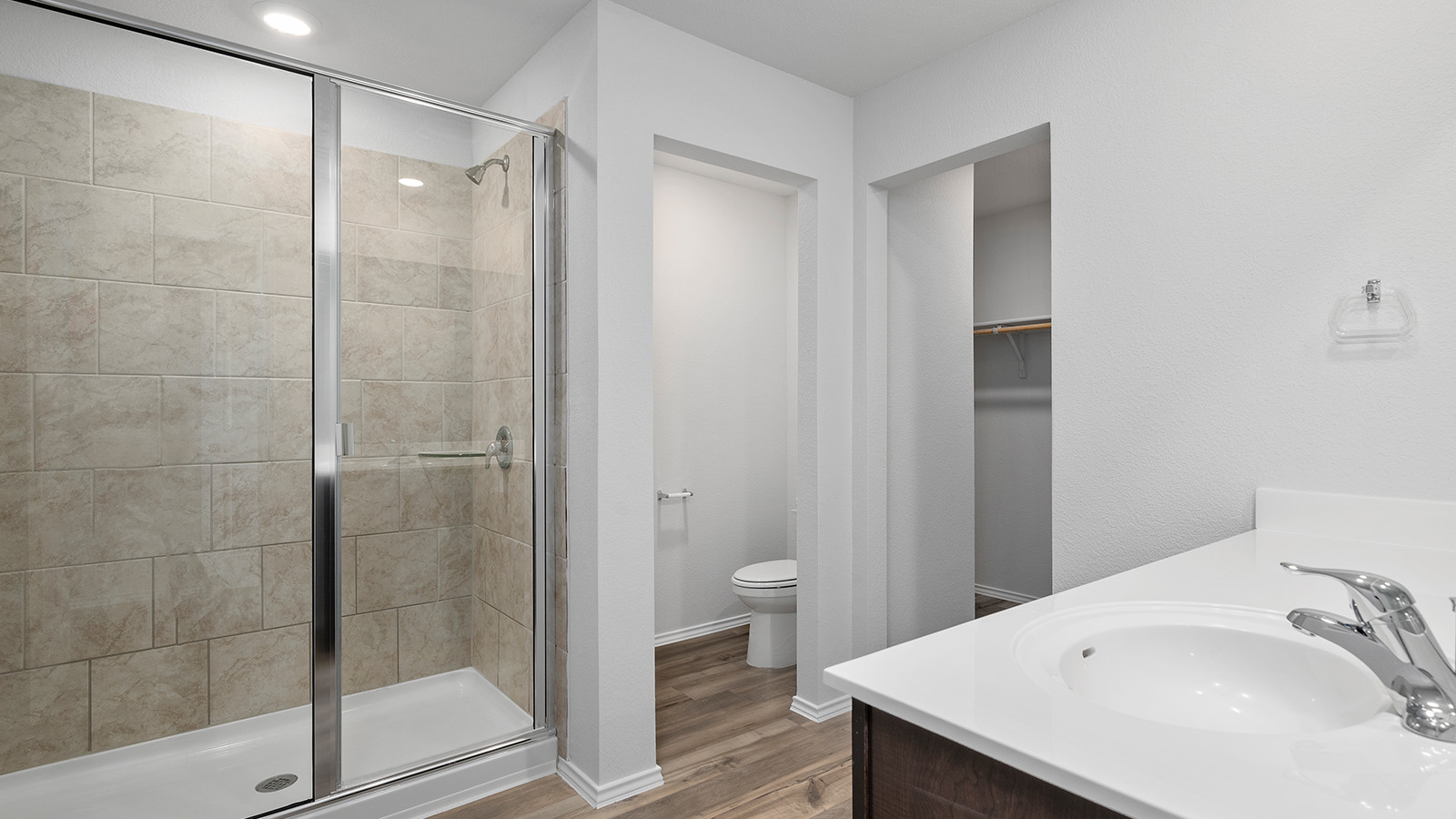1403 Victory Rnch Trail Killeen, TX 76549 - Photo 15 of 22 Bathroom featuring a glass-enclosed shower with tiled walls, a vanity with a white countertop and undermount sink, and wood-look flooring