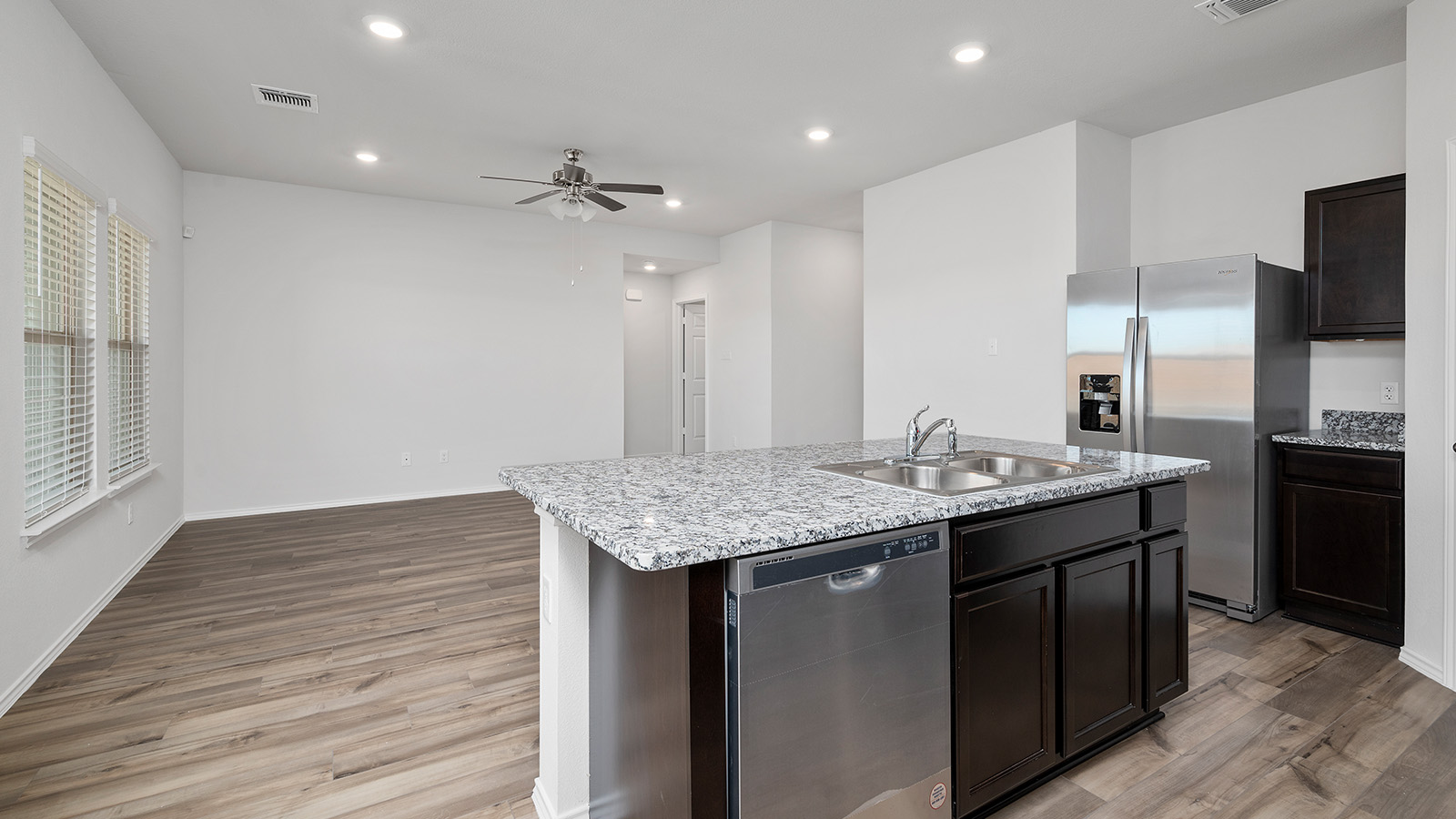 1403 Victory Rnch Trail Killeen, TX 76549 - Photo 3 of 22 The kitchen features a spacious island with a sink, stainless steel dishwasher, and dark wood cabinetry, complemented by granite countertops