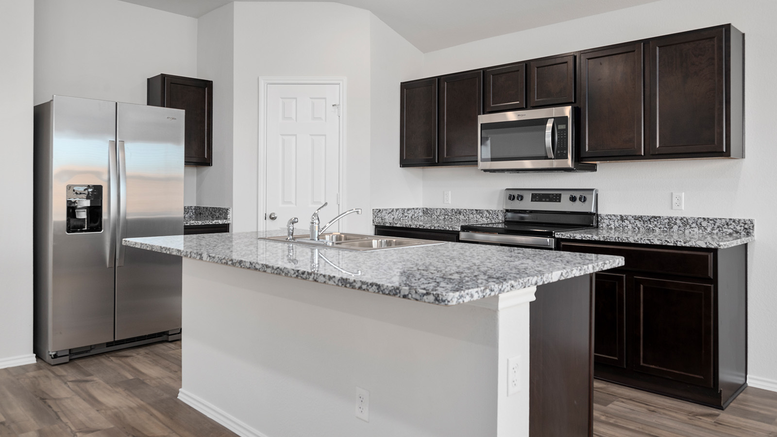 1403 Victory Rnch Trail Killeen, TX 76549 - Photo 5 of 22 The property features a kitchen with dark wood cabinetry, granite countertops, and stainless steel appliances including a refrigerator, microwave, and range