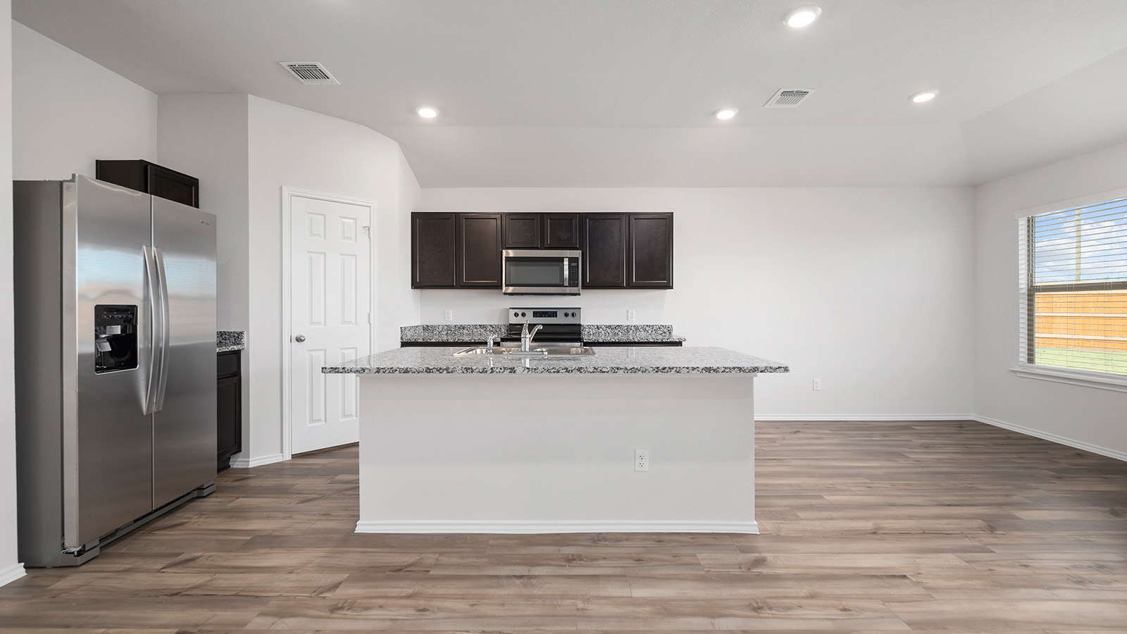 1403 Victory Rnch Trail Killeen, TX 76549 - Photo 9 of 22 Kitchen featuring stainless steel appliances, dark wood cabinetry, granite countertops, and recessed lighting