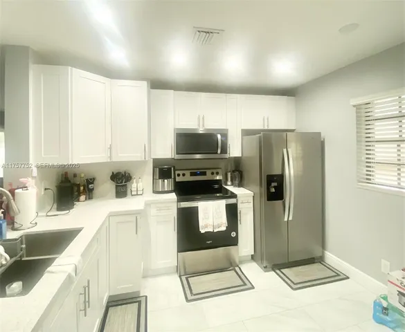 a kitchen with granite countertop a refrigerator and a sink