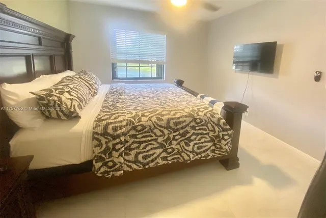 a bedroom with a bed and a flat screen tv
