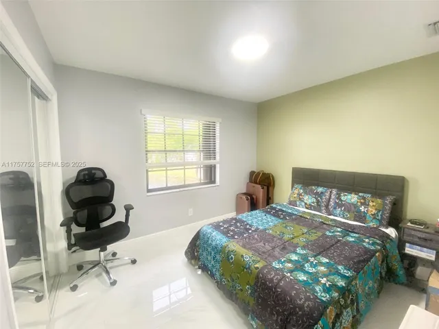 a bedroom with a bed chair and a window