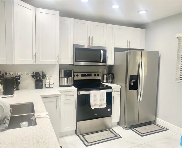 a kitchen with stainless steel appliances a refrigerator a stove a microwave and cabinets