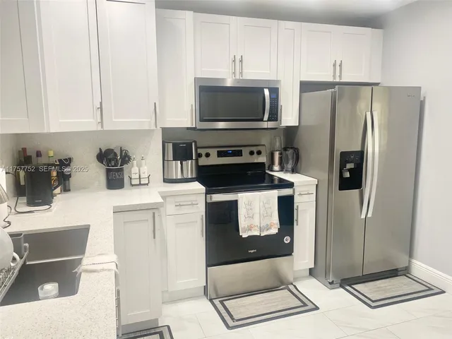 a kitchen with stainless steel appliances a refrigerator a stove a microwave and cabinets