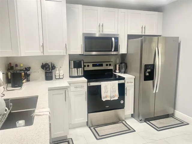 a kitchen with stainless steel appliances a refrigerator a stove a microwave and cabinets