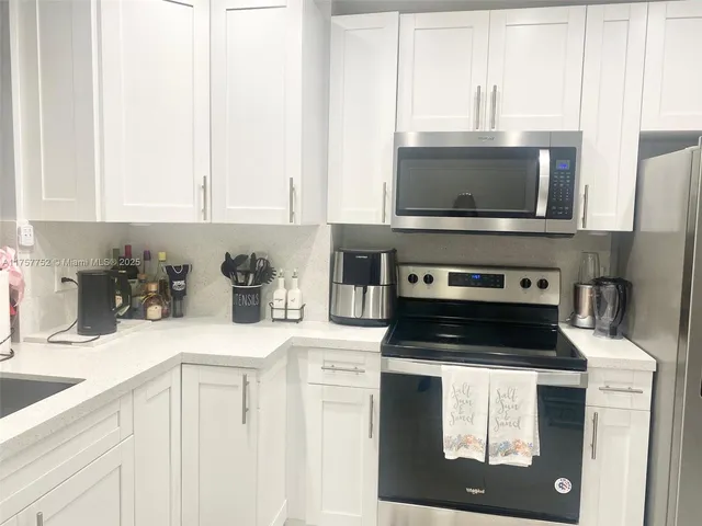 a kitchen with appliances a sink and cabinets