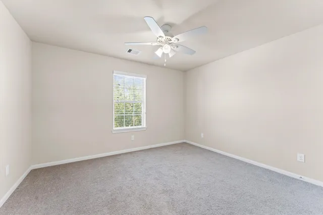 an empty room with a window and a fan