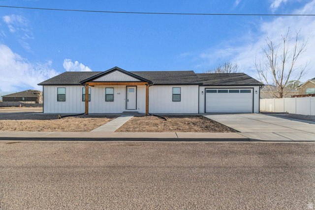 520 East 450th Street North Delta, UT 84624 - Photo 2 of 48 View of front of house with covered porch, concrete driveway, a garage, and roof with shingles