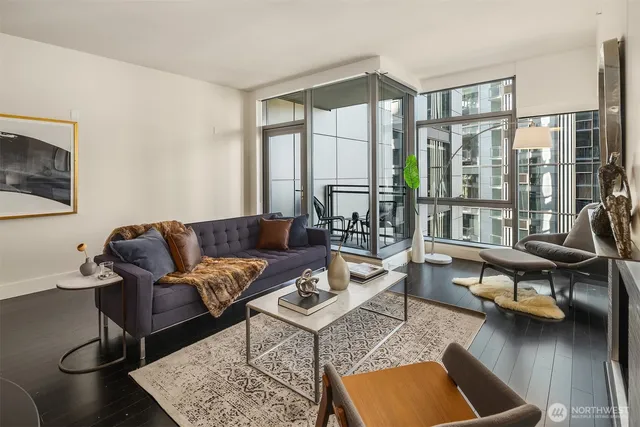 a living room with furniture a rug and a floor to ceiling window