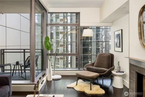 a living room with fireplace furniture and floor to ceiling windows