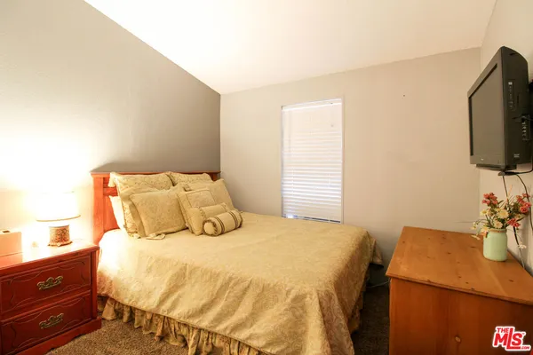 a bedroom with a bed and flat screen tv