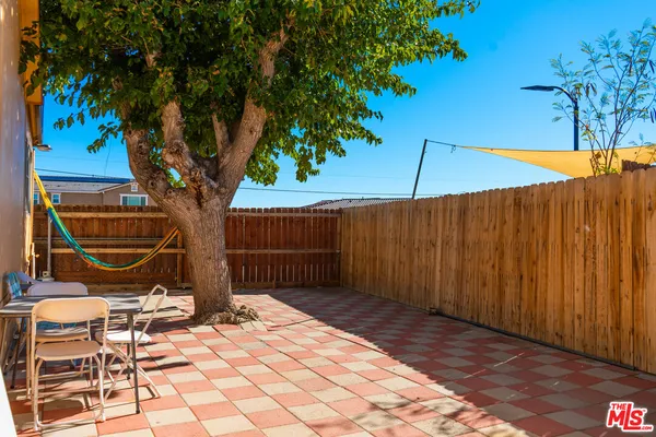 a backyard of a house with lawn chairs and iron fence