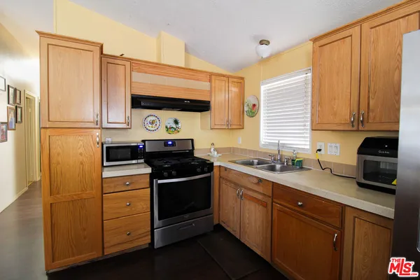 a kitchen with stainless steel appliances a stove a sink and a refrigerator