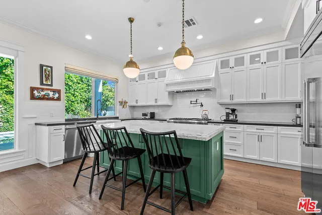 a kitchen with a table chairs and white cabinets
