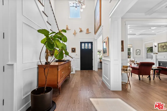 a living room with furniture a potted plant and kitchen view