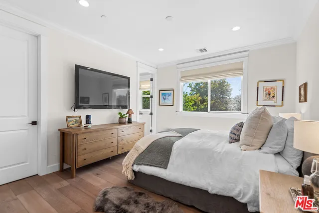 a bedroom with a large bed and a flat screen tv