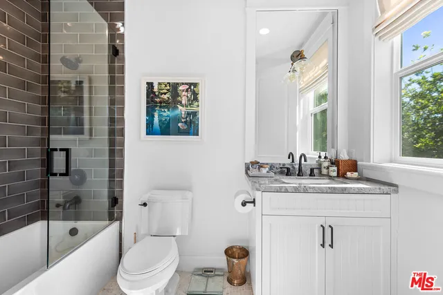 a bathroom with a granite countertop sink a toilet and shower