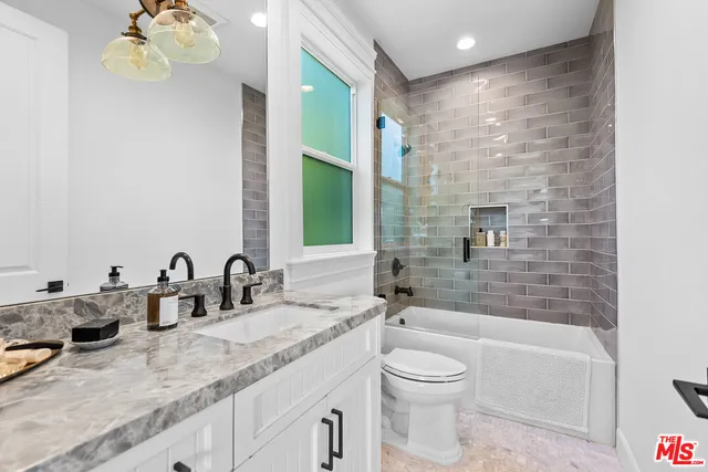 a bathroom with a granite countertop sink a toilet and bathtub