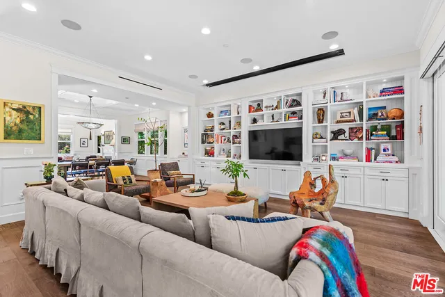a living room with furniture kitchen view and a flat screen tv