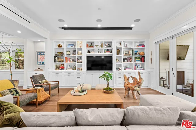 a living room with furniture kitchen view and a large window