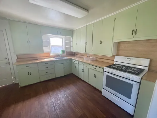 a kitchen with a stove sink and cabinets