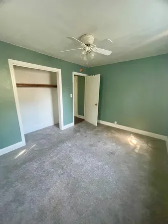 an empty room with closet and fan