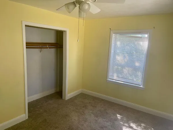 an empty room with windows and closet