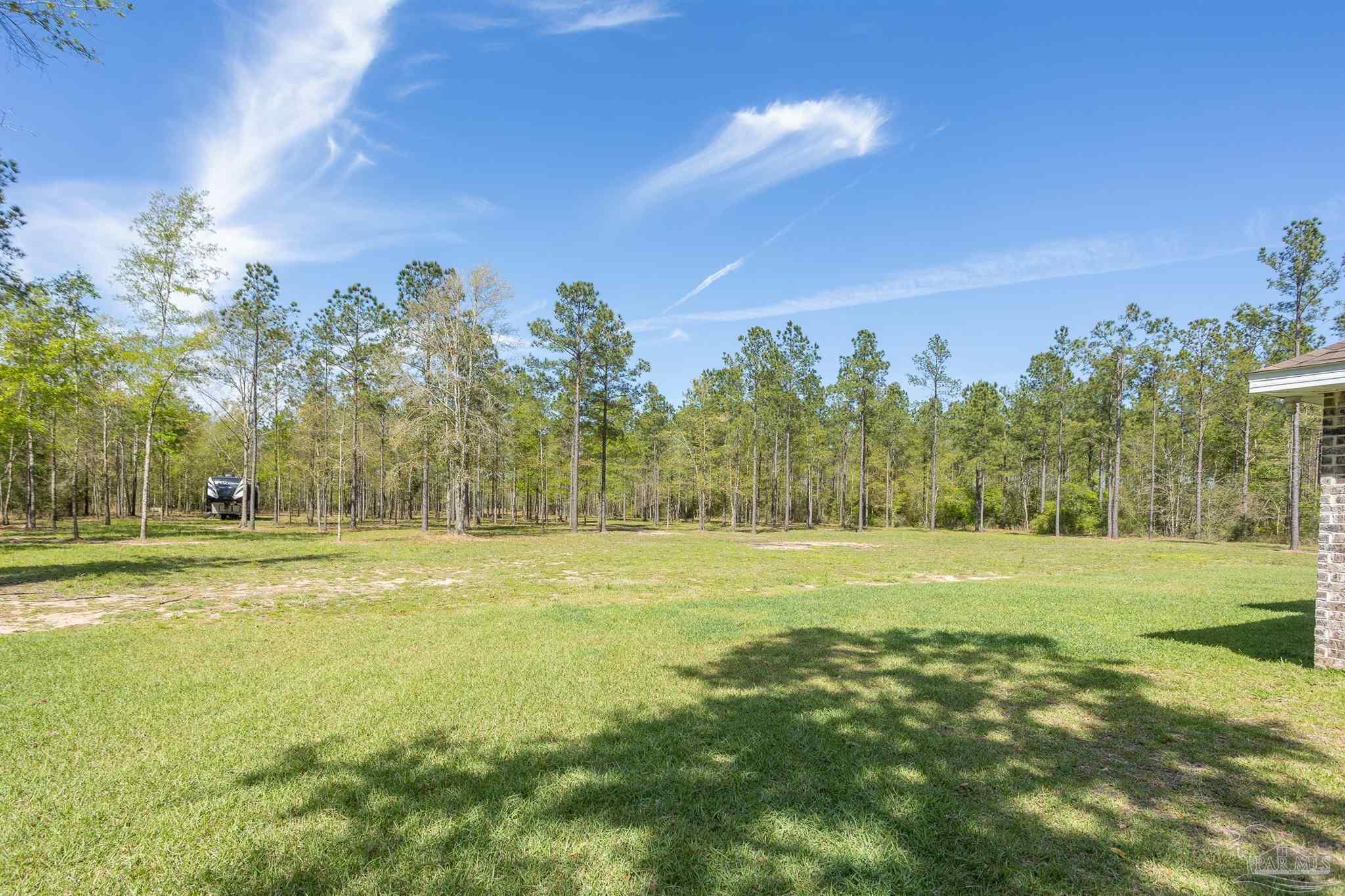 2383 Bud Diamond Road Jay, FL 32565 - Photo 35 of 50 a view of a big yard with trees and a houses