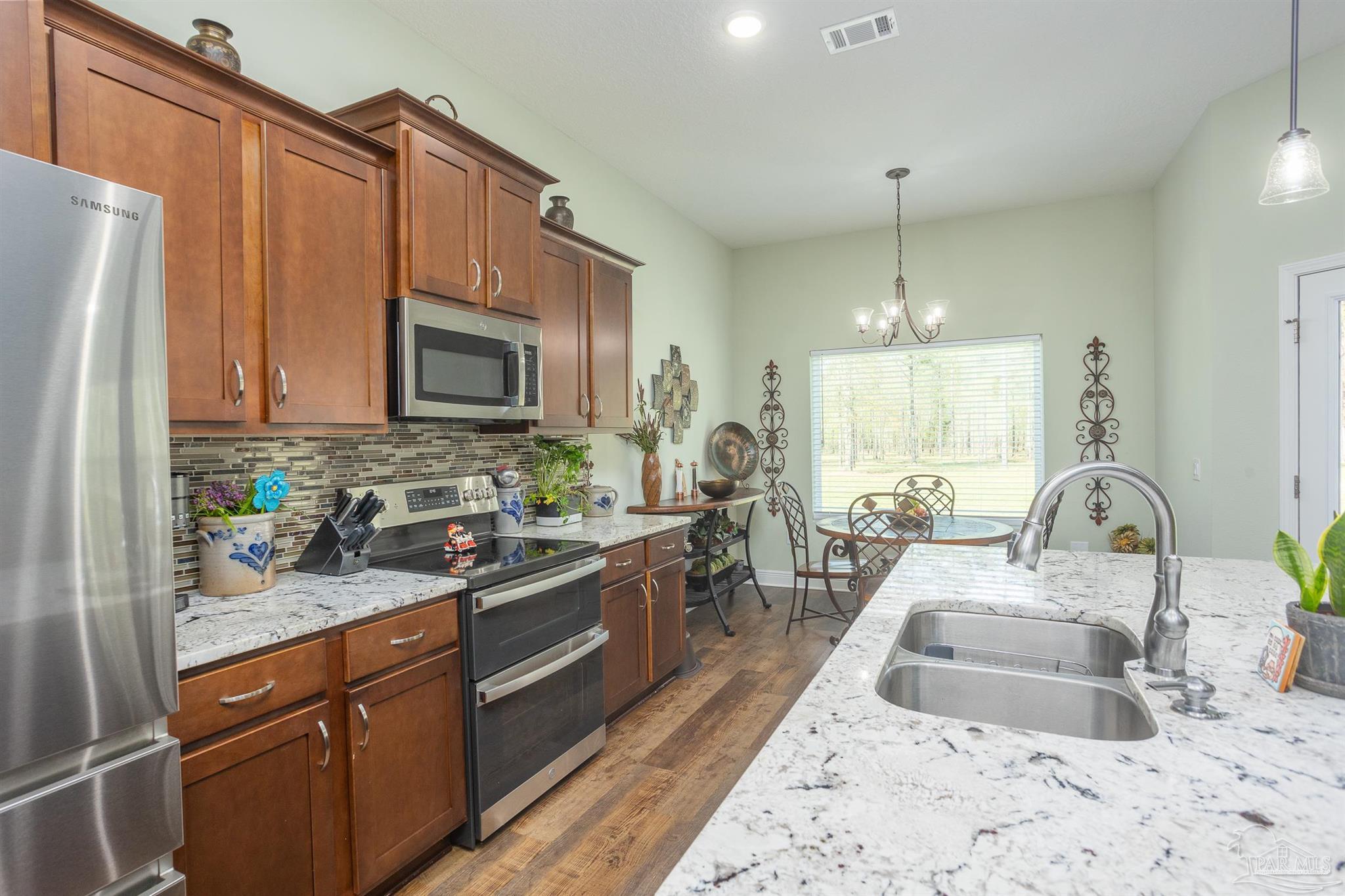 2383 Bud Diamond Road Jay, FL 32565 - Photo 5 of 50 a kitchen with stainless steel appliances a sink a stove a refrigerator cabinets and living room view