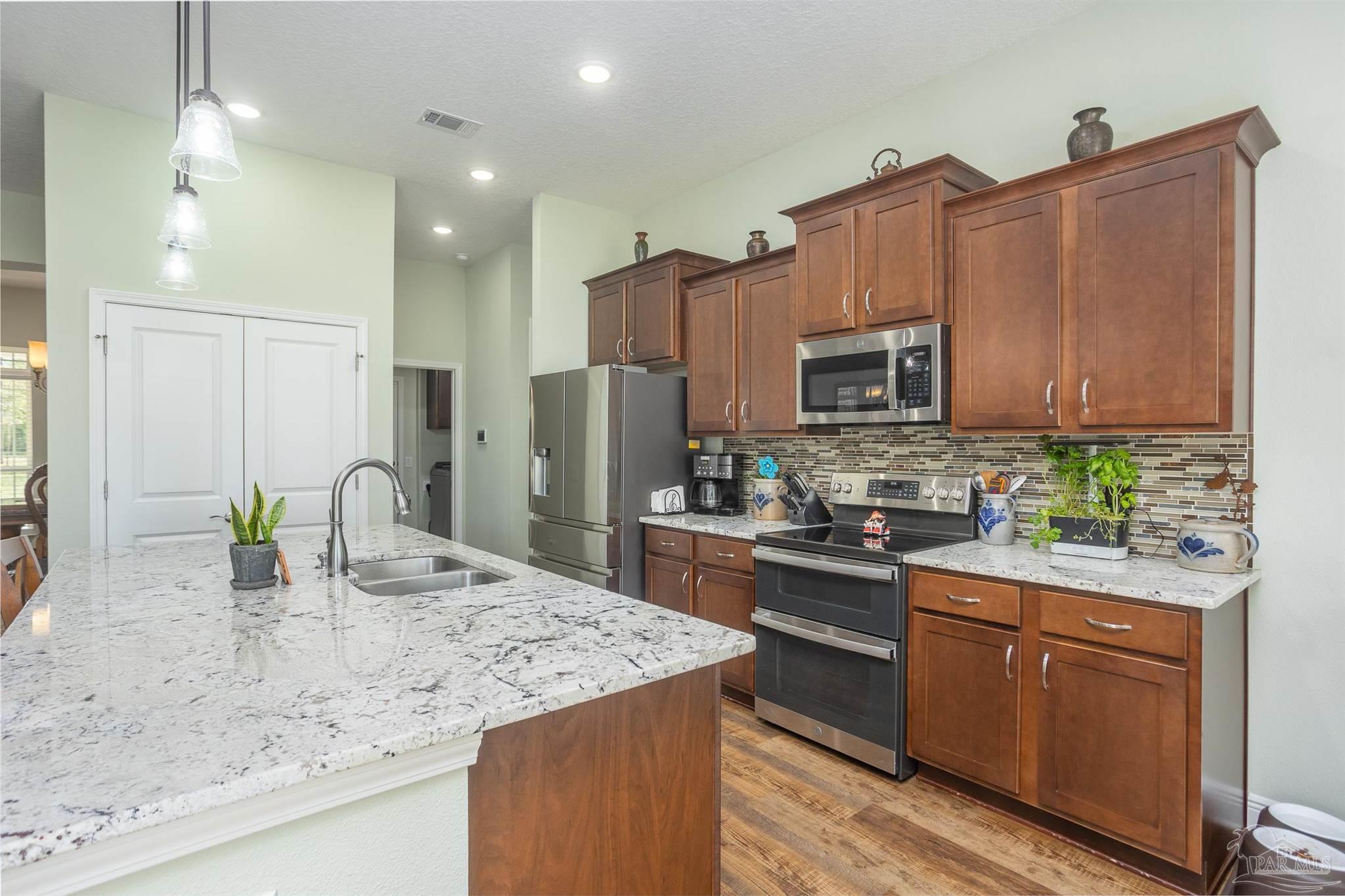 2383 Bud Diamond Road Jay, FL 32565 - Photo 8 of 50 a kitchen with kitchen island granite countertop a sink a counter top space appliances and cabinets