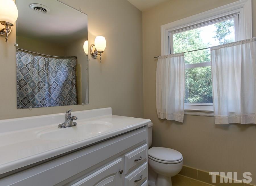 5305 Mapleridge Road Raleigh, NC 27609 - Photo 22 of 25 a bathroom with a sink a toilet and a window