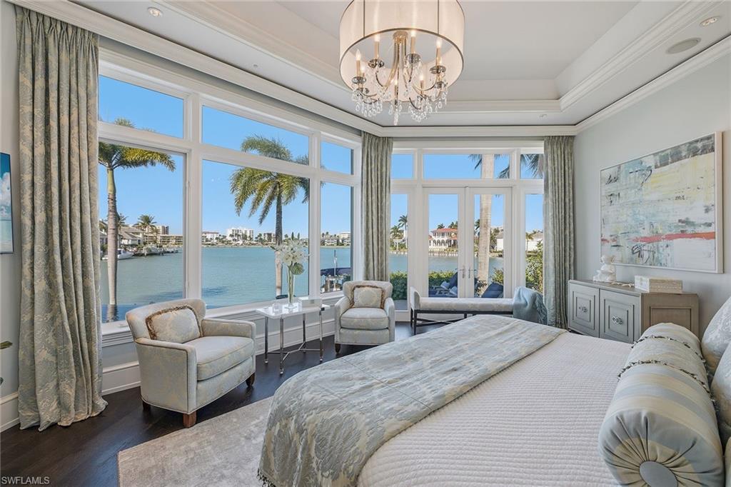 3125 Leeward Lane Naples, FL 34103 - Photo 17 of 30 a bedroom with furniture and a chandelier