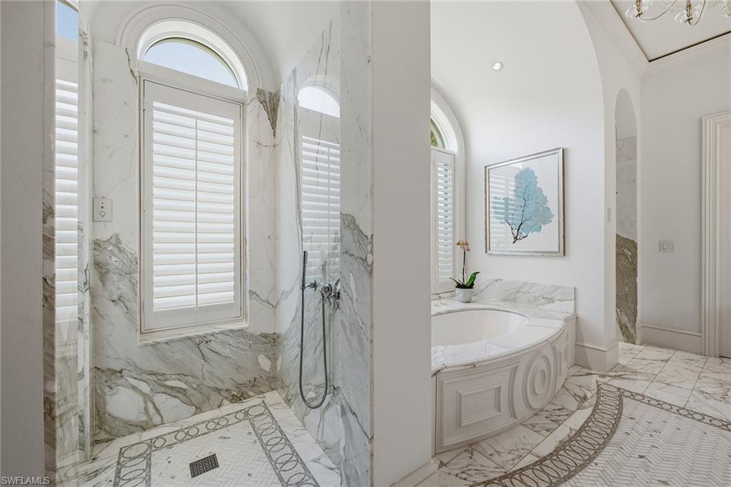 3125 Leeward Lane Naples, FL 34103 - Photo 18 of 30 a bathroom with a tub sink and mirror