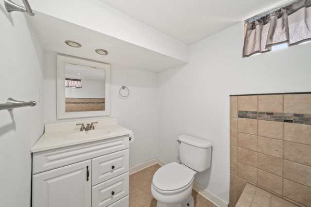 228 West Taylor Street DeKalb, IL 60115 - Photo 21 of 30 a bathroom with a toilet sink vanity and mirror