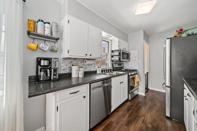 228 West Taylor Street DeKalb, IL 60115 - Photo 10 of 30 a kitchen with stainless steel appliances granite countertop a lot of counter space and wooden floors