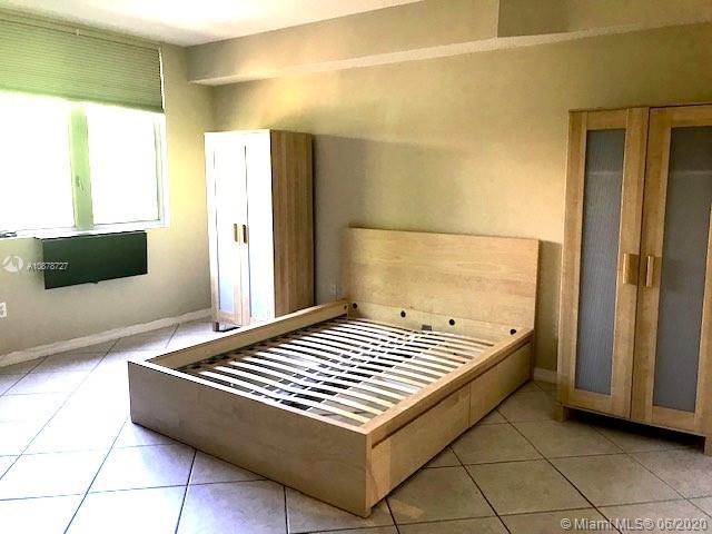 2630 Southwest 28th Street, Unit 26 Miami, FL 33133 - Photo 4 of 6 a bedroom with a bed and a flat screen tv