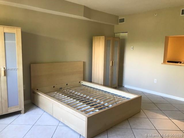 2630 Southwest 28th Street, Unit 26 Miami, FL 33133 - Photo 5 of 6 a living room with a bed and a table