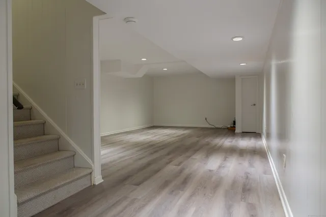 a view of an empty room with wooden floor and entryway
