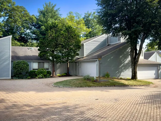 a view of a house with a yard and large tree