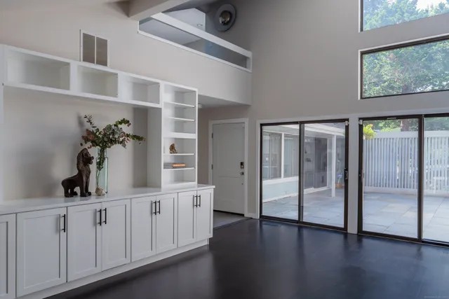 a hallway with white cabinets and wooden floor
