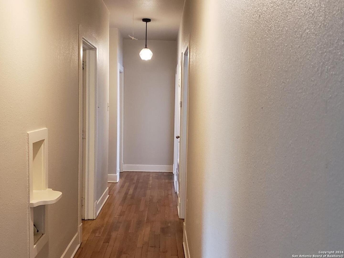 1406 Hicks Avenue San Antonio, TX 78210 - Photo 6 of 14 a view of a hallway with wooden floor