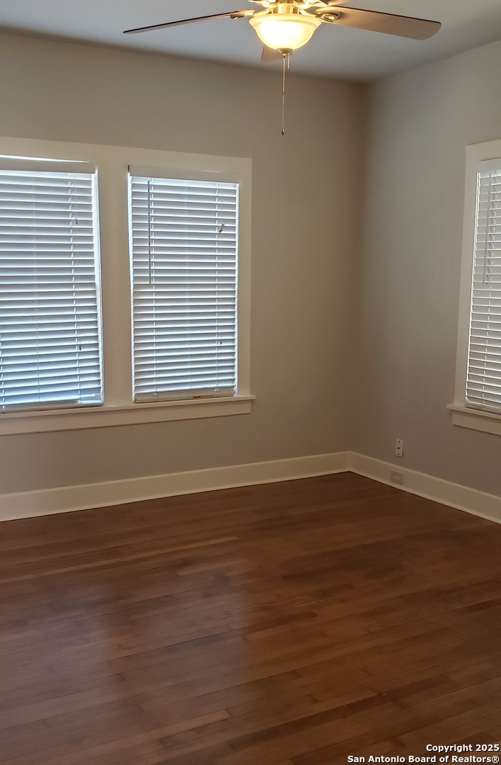 1406 Hicks Avenue San Antonio, TX 78210 - Photo 10 of 14 a view of an empty room with wooden floor and a window