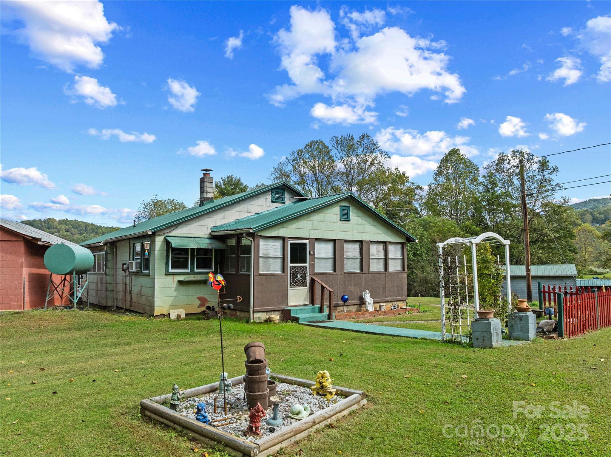 841 Elm Bend Road Brevard, NC 28712 - Photo 4 of 26 a front view of a house with a garden and trees