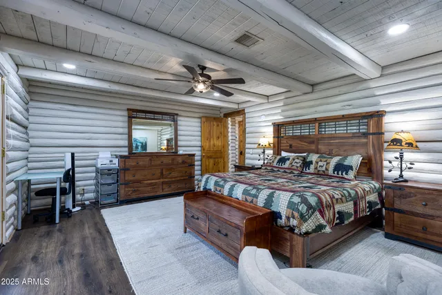 a bedroom with a bed dresser and wooden floor