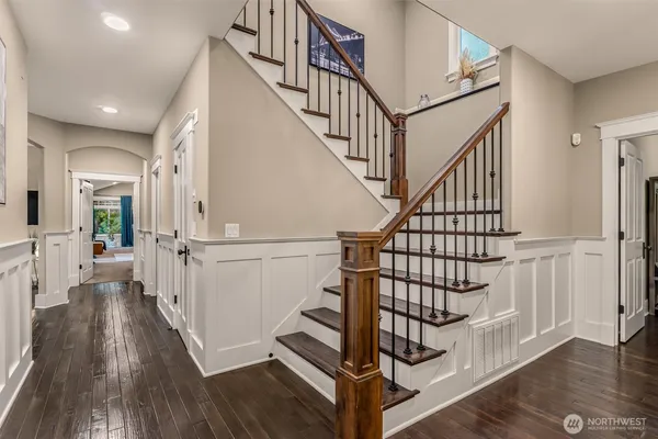 a view of staircase with wooden floor and a chandelier