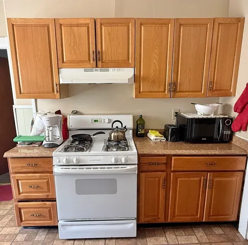 a kitchen with granite countertop wood cabinets and white appliances
