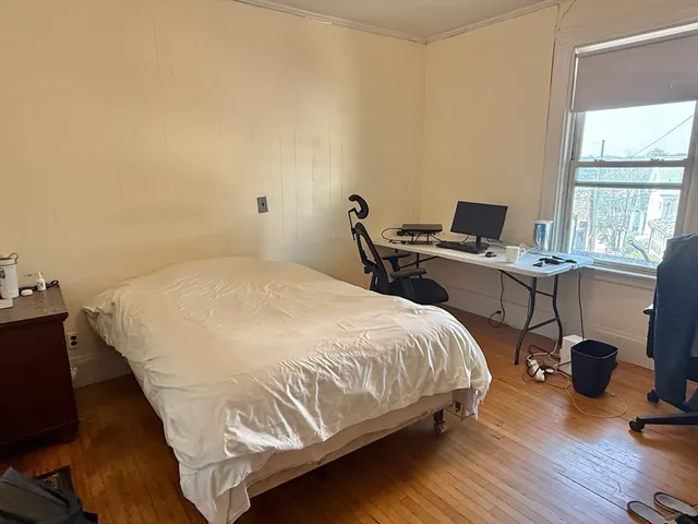 a bedroom with a bed a desk and a workspace